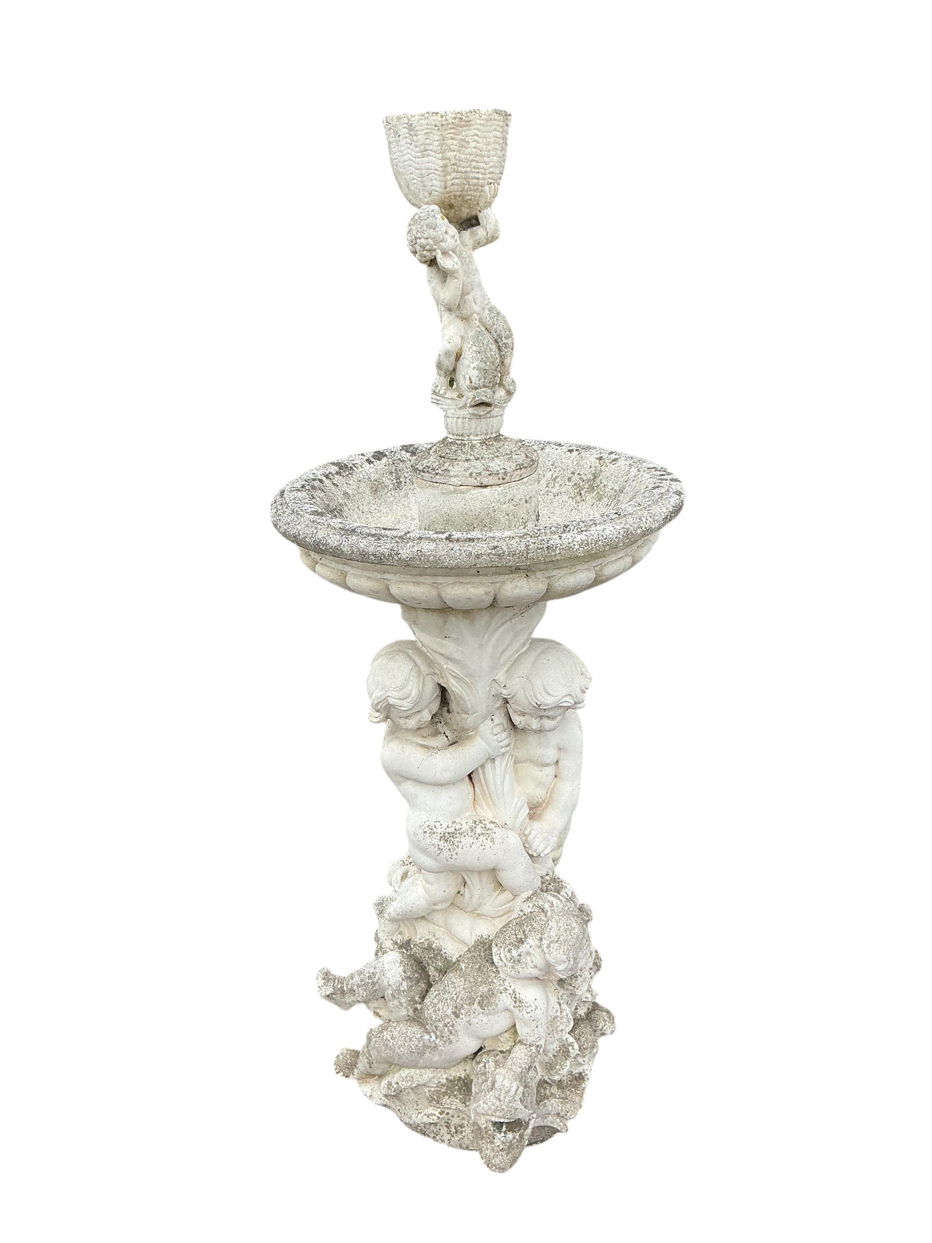 A reconstituted stone cherub and dolphin garden fountain, height 134cm